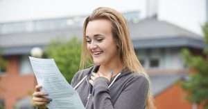 pretty girl smiling and reading her resume